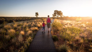 A person and child walking at sunset | Orange Naturals