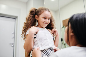 Child getting ready for school with parent's help