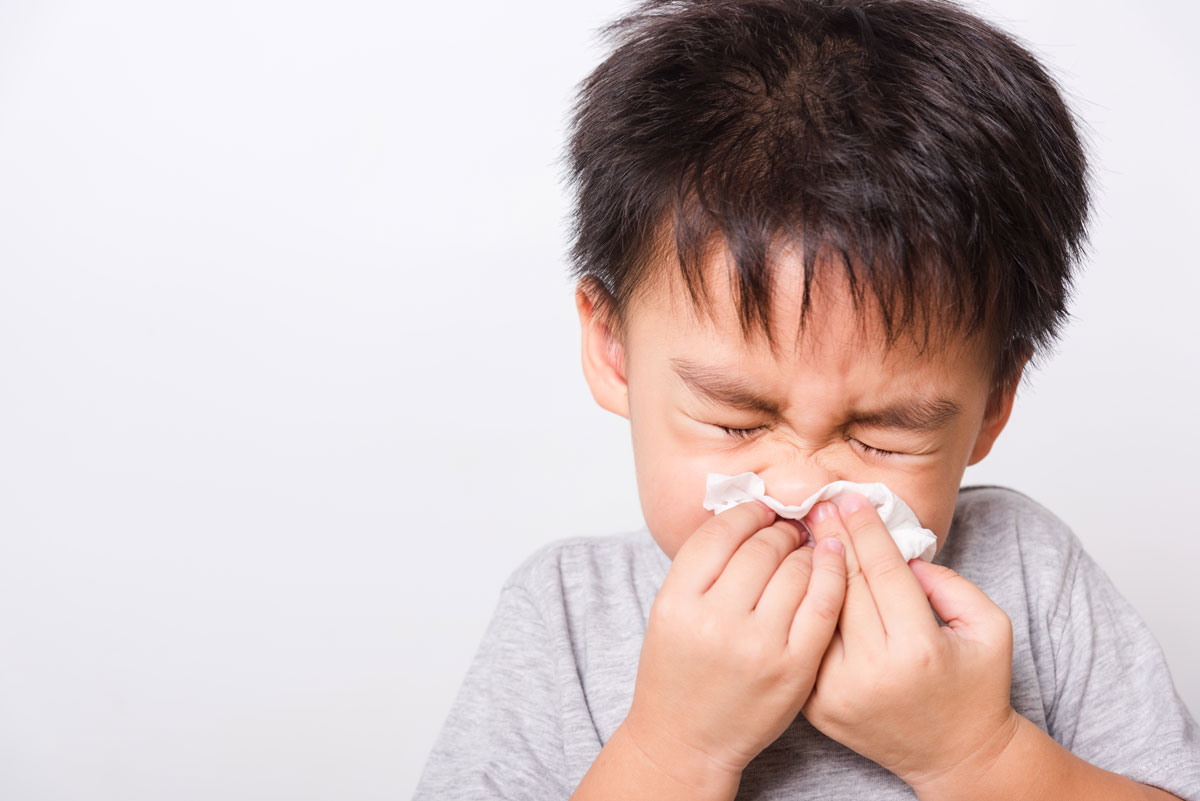 Little boy blowing his nose