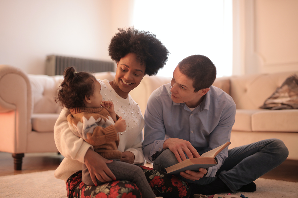 Parents reading a book to child