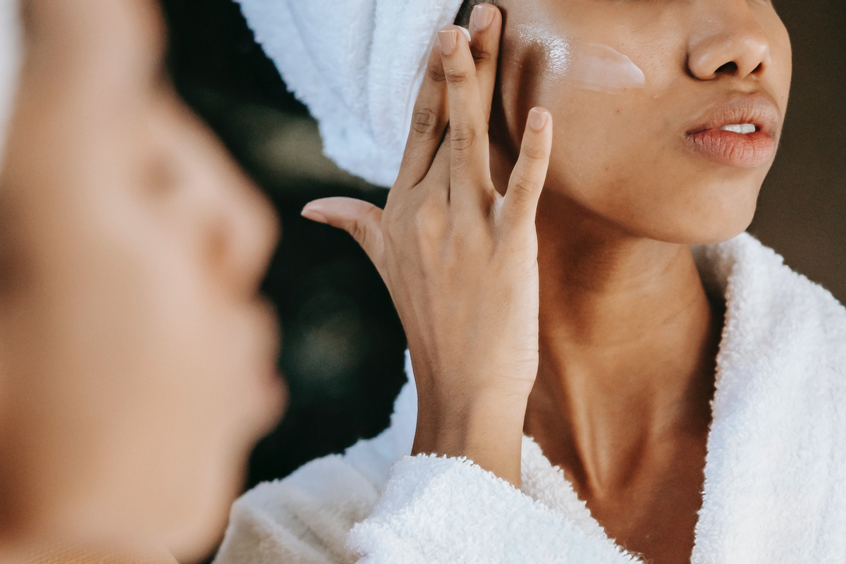 Woman applying cream to face