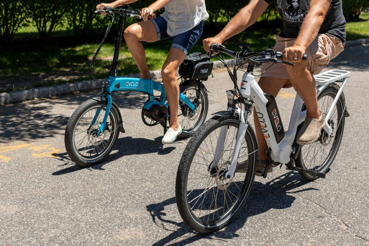 Man and woman riding bikes on a sunny day next to each other