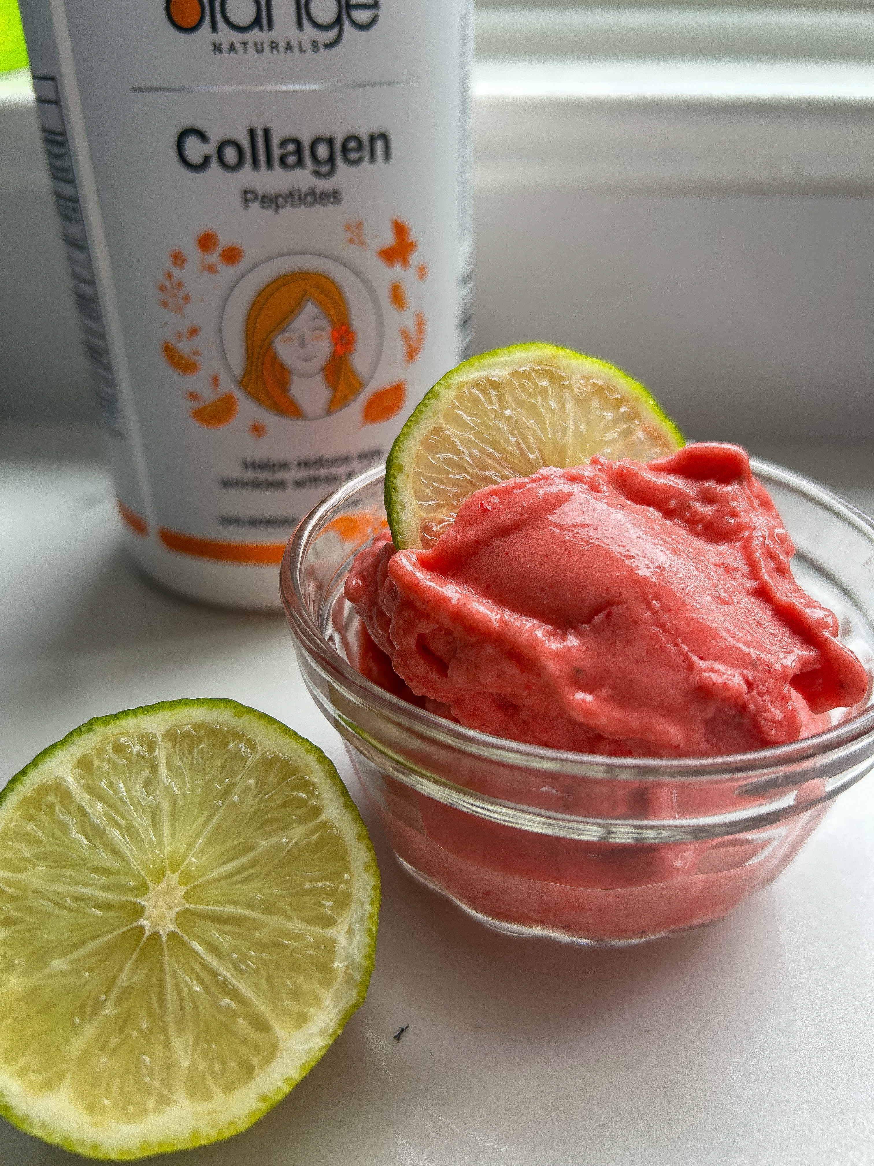 Orange Naturals Collagen Peptides tub with a small bowl of strawberry lime sorbet and a lime slice
